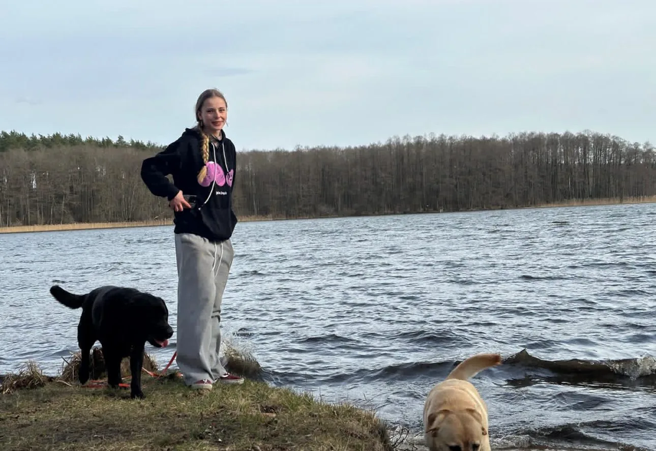 Zofia Krzemińska z dwoma labradorami nad jeziorem